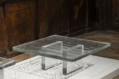 a glass table sitting on top of a white platform