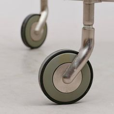 a close up of two wheels on a metal table with grey and green rims