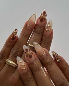 These Earthy Brown and Gold 3D Almond Nails radiate elegance with their goddess-like gold embellishments and rich brown tones.  🍎 Recreate this look yourself with our Korean Gel Nail Polish collection!  🍎 Credit: aashleysnails on Instagram  🍎 fall nails, autumn nails, september nails, earthy nails, brown nails, gold nails, 3D gel nails, goddess nails, classy nails, elegant nails, gel nail polish, autumn nail art, elegant nails, leopard print nails, cheetah nails, animal print nails, floral nails, gold accent nails, nail design, trendy nails, stylish nails, gel polish, manicure ideas, nail inspiration, nude nails, natural nails, baddie nails Gel Accent Nail Ideas, Fall Almond Acrylic Nails Designs, Gold Brown Nails Design, Almond Nails For Autumn, Simple Cream Nails, Gold Accent Almond Nails, Gold Gem Nail Designs, Nail Designs Autumn Colors, Fall Nails Trendy Brown