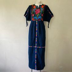 Great Pre-Owned Condition, No Defects Other Than Some Minor Signs Of Use. Beautiful Vintage Circa 1970s Guatemalan Huipil-Style Maxi Folk Dress, In A Dark Indigo Blue With Colorful Woven Designs. It Has A Pull-On Fit With No Closures, And A Low Waist With An Attached Tie - When You Tie It At The Back Of Your Natural Waist, It Cinches Up The Bodice For A Blouson Effect. It Has Half-Length Dolman Sleeves That Cinch, A Notched Neckline That Lies Open, And Pleating On The Front Of The Skirt. Mannequ Blue Bohemian Dress With Geometric Embroidery, Bohemian Blue Dresses With Geometric Embroidery, Traditional Blue Dress With Geometric Embroidery, Vintage Blue Embroidered Dresses, Blue Embroidered Maxi Dress With Intricate Details, Blue Maxi Embroidered Dress With Intricate Embroidery, Blue Maxi Embroidered Dress With Intricate Details, Folk Style Blue Festival Dress, Blue Folk Style Festival Dress