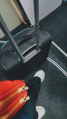 a person standing next to a black suitcase