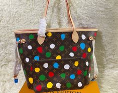 Silk screen shopping bag series polka dot master Yayoi Kusama joint series This Neverfull medium handbag combines classic design and iconic details. Crafted from soft Monogram canvas and lined in colorful fabric with calfskin trim, it's roomy without being bulky. Tighten the sides for a trendy look, and stretch for a casual look. It has a slim comfortable handle and can be worn on the shoulder or on the elbow. The detachable bag can be used as a clutch or pocket.

size: 31x28x14cm Designer Multicolor Bags For Errands, Designer Multicolor Shoulder Bag With Top Carry Handle, Designer Multicolor Shoulder Bag With Top Handle, Designer Multicolor Double Handle Bags, Designer Multicolor Bag With Removable Pouch, Designer Multicolor Bags For Everyday Use, Designer Multicolor Shoulder Bag For Shopping, Multicolor Coated Canvas Shoulder Bag With Dust Bag, Multicolor Coated Canvas Satchel Shoulder Bag