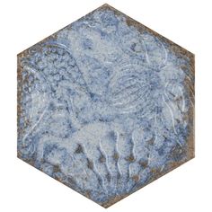 an old hexagonal tile with blue and white paint