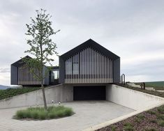 the house is built on top of a hill with a tree in front of it