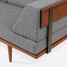 a gray couch with wooden arms and legs