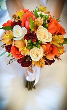 a bridal bouquet with orange, yellow and white flowers