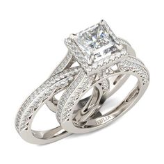 an engagement ring set with a princess cut diamond in the center and side stones on each band