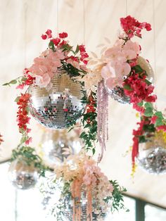 a chandelier with flowers and disco balls hanging from it