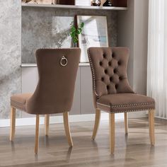 two brown chairs sitting next to each other on top of a hard wood floored floor