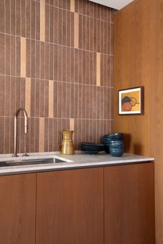 a kitchen with wooden cabinets and tile backsplashing on the wall above the sink