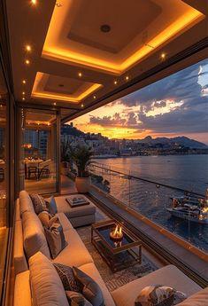 a living room filled with lots of furniture next to a large window overlooking the water