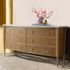 a wooden dresser sitting next to a wall with vases on it's top