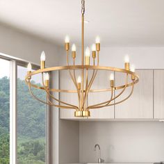 a large chandelier hanging from the ceiling in a kitchen with white counter tops