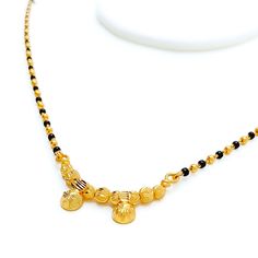 This exquisite Thali Mangal Sutra, crafted in 22k yellow gold, weighs 9.2 grams and features a classic design adorned with traditional black beads. With a necklace length of 16" and a subtle 0.25" drop, it embodies grace and simplicity. Secured with a hook lock, this piece is a timeless representation of cultural heritage, perfect for daily wear or special occasions, adding a touch of elegance and meaning to any ensemble. PRODUCT DETAILS Gold Purity(karat): 22k Item Weight(grams): 9.2 Item Finish: Yellow Gold Stone: Black Bead Necklace Length: 16" Drop Length: 0.25" Lock Style: Hook Lock Black Temple Jewelry Necklace For Diwali, Traditional Black Temple Necklace For Puja, Black Round Beads Necklace For Diwali, Black Temple Jewelry Necklaces For Puja, Black Temple Jewelry Necklace For Puja, Black Beaded Necklace For Diwali, Festive Black Necklace For Puja, Black Beaded Necklaces For Diwali, Festive Black Beads Necklace For Puja