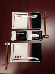 three black and white plates with chopsticks on them