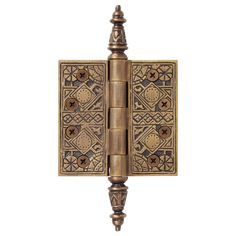 an antique brass door hinge with decorative designs on the front and back sides, isolated against a white background