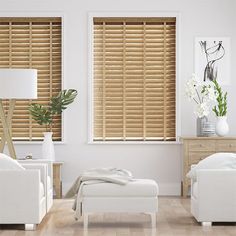 a living room with white furniture and wooden blinds