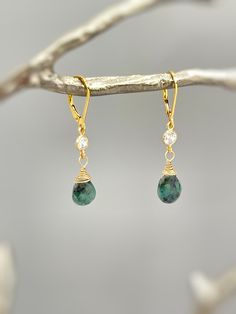 Genuine Emerald Earrings. Dainty handmade crystal dangle tear drop earrings.  Dainty raw emerald gemstone tear drops are wire wrapped in 14k gold fill or sterling silver and hang from sparkling bezel set crystals. Matching French hook or leverback earring backs available. Gemstone drops are dainty approx 8x9mm. Simple, elegant everyday earrings. Lightweight elegant earrings.  Emeralds are organic in nature and contain some color variations and inclusions. Please see photo for some examples. Emer Delicate Adjustable Teardrop Jewelry, Dainty Nickel-free Teardrop Jewelry, Delicate Drop Earrings With Ear Wire, Green Teardrop Jewelry With Ear Wire, Dainty Drop Earrings With Natural Stones, Adjustable Teardrop Pendant Earrings As Gift, Green Drop Jewelry For Jewelry Making, May Birthstone Crystal Drop Earrings, Teardrop May Birthstone Earrings