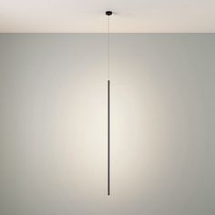 a light that is hanging from the ceiling in a room with white walls and flooring