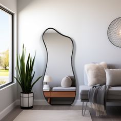 a living room with a couch, mirror and potted plant