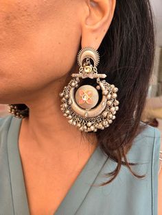 Statement silver boho ghungroo Kundan chandbaali earrings for a stunning look. Perfect for adding a unique and stylish touch to any outfit. Earring Dimensions:  Approximately 3.2 Inches Long  Approximately 2 Inches Wide  A Earring Weight is 1.3 oz All our products are crafted using traditional skills from our rich heritage. The manual nature of these crafts means that irregularities or variations are inherent in the handcrafting process. Fusion Style Danglers With Latkans For Navratri, Silver Meenakari Chandelier Earrings For Festivals, Bohemian Kundan Chandbalis With Intricate Design, Fusion Style Chandbali Jewelry With Oxidized Finish, Fusion Kundan Chandbalis With Latkans, Fusion Style Kundan Chandbalis With Latkans, Bohemian Tilla Dangle Earrings, Fusion Style Dangle Jhumkas, Festive Fusion Hoop Earrings