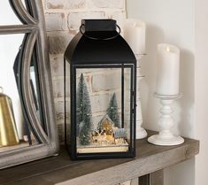 a lit lantern sitting on top of a mantle next to a mirror