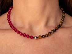 "Refine your style with this exquisite choker necklace, handcrafted with a striking combination of beaded Brown Tiger's Eye, Silver Hematite and Fuschia Jade strung on black knotted silk. Each bead is carefully selected for its natural variations, lending the piece a unique and nuanced identity. The black knotted silk provides a sophisticated backdrop for the shimmering beads, while the choker style adds a bold and contemporary touch to any outfit. Whether you're dressing up for a special occasion or elevating your everyday look, this handmade modern crystal jewelry is designed to inspire and uplift. Experience the transformative power of crystals with this stunning choker necklace. Brown tiger's eye is believed to promote grounding and stability, enhancing inner strength, courage, and sel Elegant Choker With Natural Stones And Round Beads, Elegant Choker With Round Natural Stones, Beaded Necklaces With Round Beads For Healing, Spiritual Choker With Natural Round Beads, Spiritual Natural Stones Round Beads Choker, Healing Beaded Necklaces With Round Beads, Spiritual Choker With Round Natural Stones, Healing Gemstone Beaded Necklaces, Gift Choker With Polished Round Beads