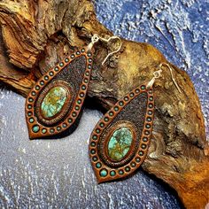 This pair of hand tooled and hand painted leather earrings with beautiful chrysocolla cabochons could become a nice addition to your Boho, hippie, casual, beach, Western clothes. Earrings are made with sterling silver hooks. This piece was MADE TO ORDER, thus in not available. If you would like me to make something for you please contact me for a custom order and we'll discuss the details. I've got plenty of different cabochons in stock, thus I believe we would find something just for you. The p Bohemian Hand-tooled Leather Earrings, Rustic Hand Tooled Leather Jewelry, Brown Southwestern Jewelry With Patina, Southwestern Brown Jewelry With Patina, Handmade Rustic Leather Earrings, Handmade Leather Turquoise Earrings, Handmade Turquoise Leather Earrings, Handmade Leather Earrings In Turquoise, Artisan Leather Nickel-free Earrings