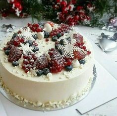 a white cake with berries and snowflakes on it