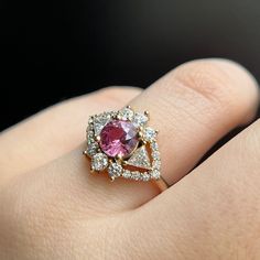 Similar to our blue sapphire version, this pink beauty features a 1.49ct pink sapphire surrounded by sparkly white diamonds. She's the perfect art-deco inspired engagement ring for someone who is into a nontraditional engagement look. Please note resizing this ring adds an extra 7-10 days for delivery. Pink Marquise Cut Diamond Ring, Fine Jewelry Pink Diamond Ring Marquise Cut, Fine Jewelry Pink Marquise Cut Diamond Ring, Fine Jewelry Pink Round Cut Diamond Ring, Pink Round Cut Diamond Ring, Pink Pear-shaped Diamond Ring, Pink Sapphire Ring With Brilliant Cut Diamond, Dazzling Pink Diamond Ring With Accent Stones, Pink Diamond Ring With Accent Stones