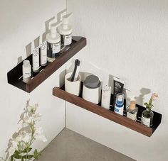 two wooden shelves holding different types of personal care products and flowers in vases next to each other