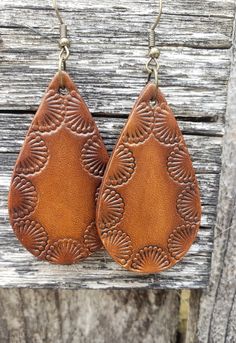 Shades of warm caramel are surrounded by an intricate Southwestern design that makes these earrings pop. Crafted from premium veg-tanned leather, these earrings are dyed by hand making them a truly unique, one-of-a-kind pair.  All leather earrings are conditioned with beeswax, which keeps the leather supple and water resistant (as seen in video). Edges and backs are finished, as well. Please remember that time and wear ages leather beautifully, transforming your pieces into truly personalized je Nickel-free Brown Bohemian Earrings, Brown Bohemian Dangle Earrings, Southwestern Style Brown Teardrop Jewelry, Brown Southwestern Teardrop Jewelry, Southwestern Brown Teardrop Jewelry, Southwestern Style Teardrop Brown Jewelry, Bohemian Brown Pierced Earrings, Southwestern Concho Earrings For Festivals, Brown Bohemian Concho Earrings