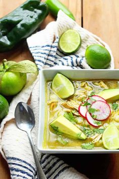 a white bowl filled with soup next to limes