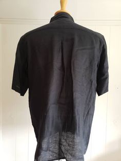 This is a vintage, Bruno, black, short sleeved, washable linen shirt with a collar and buttons down the front. The measurements are: Armpits: 24.5 inches across Length from back of the neck: just shy of 30 inches Don't forget to stop in at my other Etsy shop... http://www.etsy.com/shop/xtdesigns If you have a wish list or are looking for something specific, please ask. I may have exactly what you are looking for. As always please convo me with any questions or concerns regarding this item or wit Fitted Short Sleeve Black Shirt With Buttons, Black Linen Button Shirt, Black Collared Short Sleeve Shirt With Button Closure, Black Collared Linen Shirt, Black Linen Collared Shirt, Classic Black Linen Shirt, Black Johnny Collar Short Sleeve Shirt, Black Short Sleeve Shirt With Spread Collar, Black Cotton Short Sleeve Shirt With Spread Collar