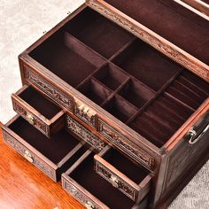 an open wooden jewelry box sitting on top of a table