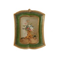 an ornate framed painting with flowers in the center and a bear on it's back