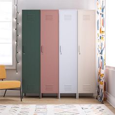 three lockers in a room next to a yellow chair and window with curtains on the windowsill