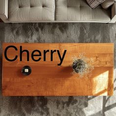 a wooden sign sitting on top of a carpeted floor next to a white couch