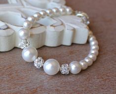 A sweet Pearl bridal bracelet is made with graduating ivory white Swarovski pearls in a single strand style, for an elegant and classical bridal accessory with a little sparkle.  Crystal 'disco' beads accentuate the central pearls and add a little pop to this cute bracelet.Matching earrings and necklace are available as a set or as stand alone pieces.Ivory white Swarovski pearls are the whitest available and due to their lustrous and delicate sheen, match the vast majority of bridal whites and i Wedding Pearl White Beaded Bracelets, Pearl Beaded Bracelets With Pearl Charm For Wedding, Adjustable Pearl Embellished Bracelet For Wedding, White Pearl Embellished Bracelets For Wedding, White Pearl Beaded Bracelet For Wedding, Adjustable Pearl Drop Bracelet For Weddings, Classic White Pearl Bracelet For Wedding, Elegant White Bracelet For Bridal Shower, Wedding Bracelets With Pearl Charm