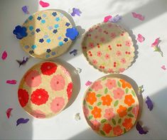 three paper plates sitting on top of a table covered in confetti and butterflies