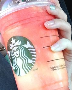 a woman holding a starbucks drink in her hand