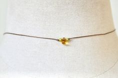 Simple and dainty.Features a glass citrine teardrop,tiny green glass beads,brown nylon cord.Necklace measures 14” with a 2” extension.Necklace finishes with a lobster claw closure.If you would like this longer or shorter just leave a note to seller at checkout. Dainty Adjustable Tiny Beads Choker, Handmade Delicate Adjustable Choker, Delicate Handmade Adjustable Choker, Dainty Adjustable Choker With Tiny Beads, Minimalist Adjustable Tiny Beads Choker, Dainty Adjustable Festival Choker, Adjustable Delicate Chain Choker, Adjustable Dainty Choker As A Gift, Minimalist Tiny Beads Choker As Gift