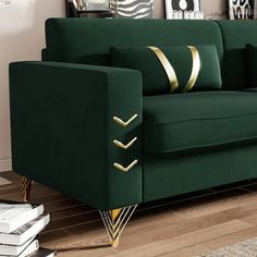 a green couch with gold trim on the arms and back, in a living room