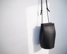 "Classic yet contemporary bucket bag, combined a minimalism and functional. The body made from Italian vegetan leather, using leather cord for the shoulder strap. The shoulder strap is adjustable, able to enjoy this bag for 3 ways as a crossbody bag, one-shoulder bag and handbag. Has a card sized inside pocket. Approximate Dimensions: W 4.75\" x H 8\" x D 4.75\" W 12cm x H 20cm x D 12cm Inside pocket W 3.50\" x H 3.50\" W 9.5cm x H 9.5cm - 100% Vegetable tanned leather (body) - Genuine leather c