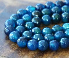 blue glass beads are arranged on a wooden surface