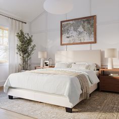 a bedroom with a bed, nightstands and two lamps on either side of the bed