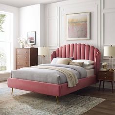 a bed with pink headboard and foot board in a white room next to a window