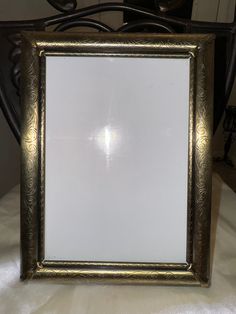 a gold framed mirror sitting on top of a table