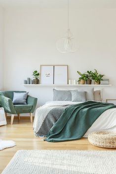 a bedroom with white walls and wooden flooring is decorated in shades of green, gray and white