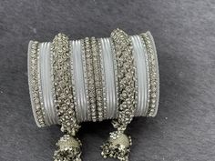 NAZRANAA JEWELS OFFERS A GREAT RANGE OF INDIAN JEWELRY FOR TODAY'S WOMAN WITH THE LATEST DESIGNS. THE BRAND IS COMMITTED TO PROVIDING ITS CUSTOMERS WITH THE HIGHEST QUALITY OF GOODS AND NEWEST DESIGNS. IT IS SUITED FOR A WOMAN WHO IS LOOKING TO STAY DATED WITH THE LATEST TRENDS. RADIANT SILVER BANGLES IS A PERFECT ACCESSORY FOR ANY NIGHT EVENT. IT IS SURE TO MAKE YOU STAND OUT IN A CROWDED ROOM. Traditional Indian Jewelry: Slight Color variations possible due to difference in screen and photogra Adjustable Silver Bangle For Wedding, Silver Bracelets With Stone Work For Party, Silver Stone Work Bangle, Traditional Silver Bangle For Marriage, Traditional Silver Bracelets For Marriage, Traditional Silver Bracelet For Marriage, Silver Bracelet With Stone Work For Festive Occasions, Silver Bracelets With Stone Work For Festive Occasions, Festive Silver Bracelet With Stone Work